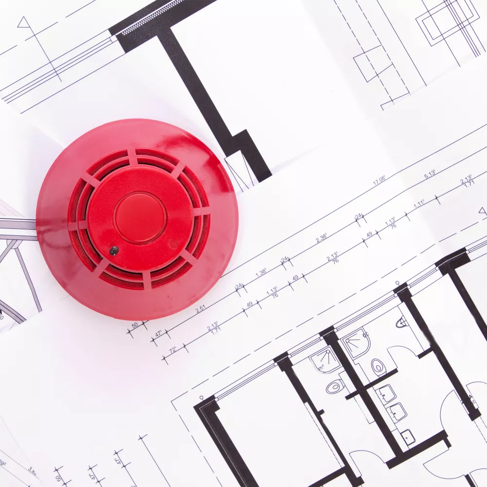 Smoke detector lies on building floor plan