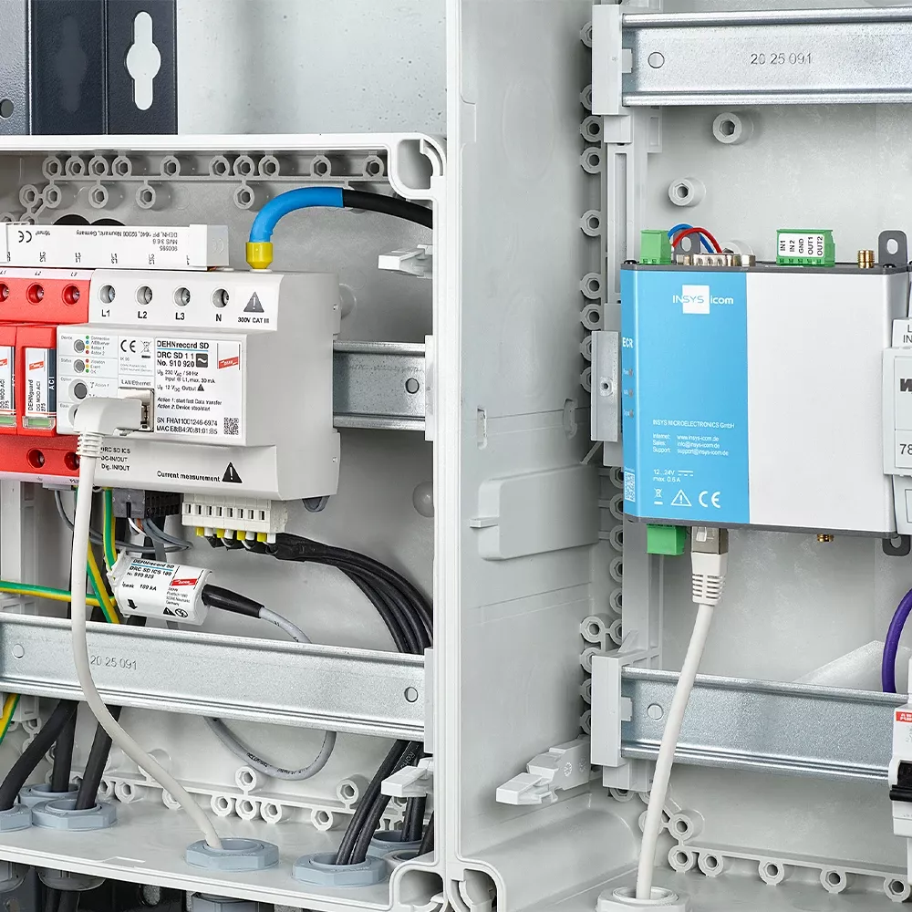Electrical cabinet with DEHNrecord SD and INSYS icom module installed on DIN rails, connected by multiple cables.